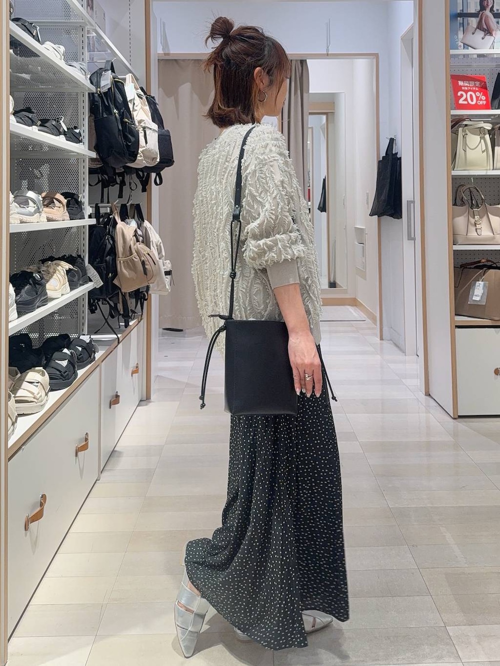 ブルー系のデニムパンツ、ブラック系のショルダーバッグ、ブラック系のタンクトップを着用したレディースの春コーディネートの5枚目の写真