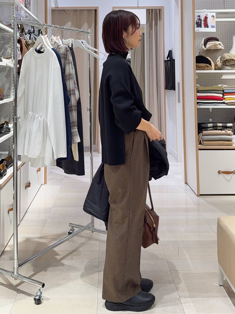 ブラック系のブルゾン、ブラウン系のボストンバッグ、ブラック系のブーツを着用したレディースの秋コーディネートの6枚目の写真