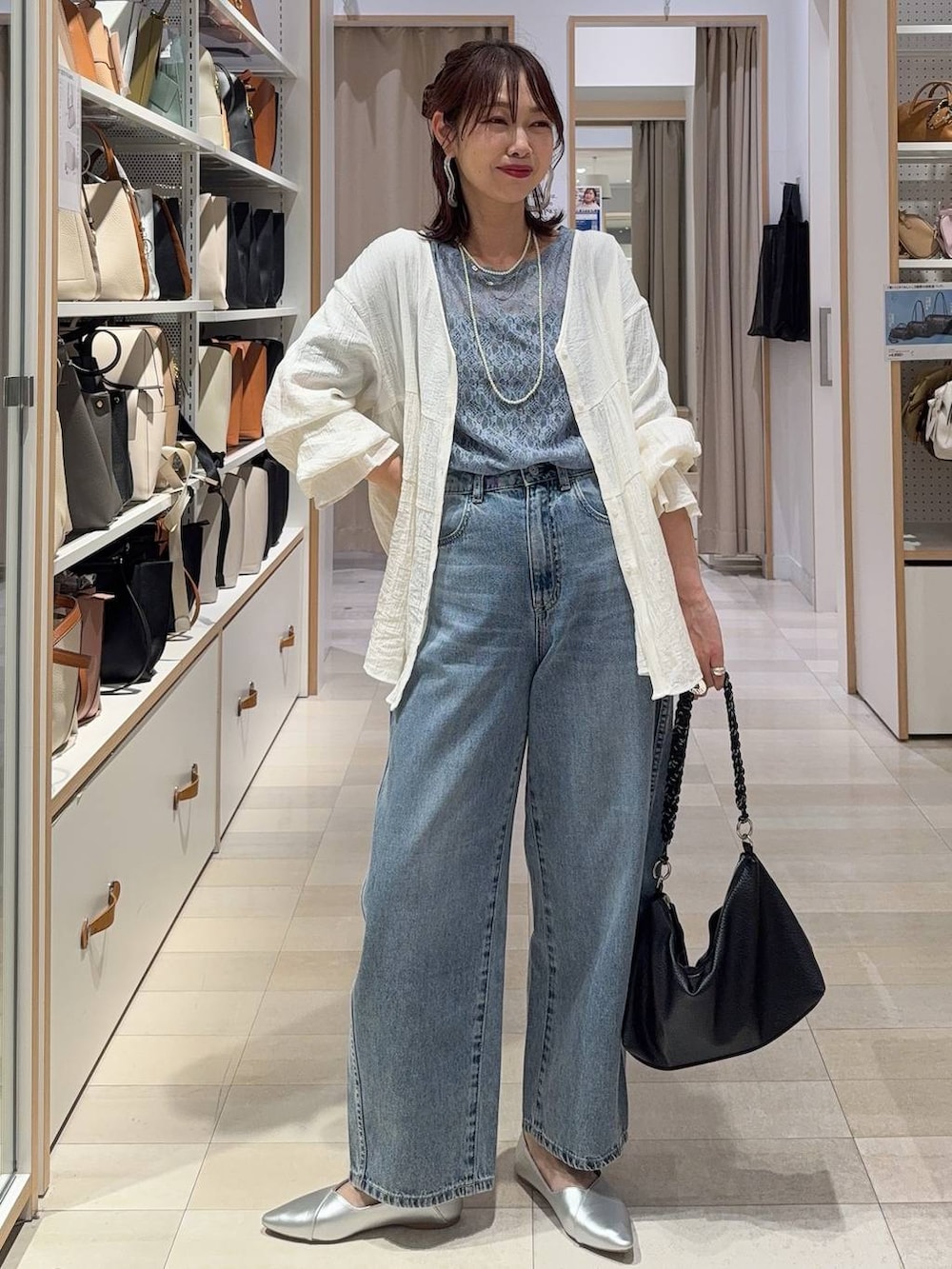 ブラウン系のベスト、ブルー系のデニムパンツ、その他のネックレスを着用したレディースの春コーディネートの7枚目の写真