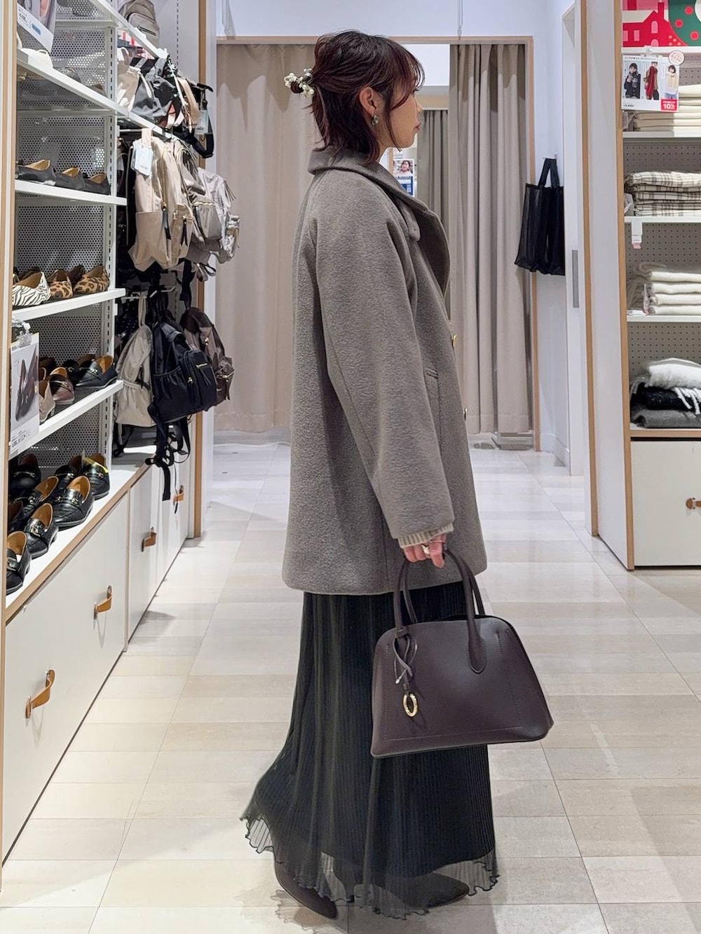 ブラウン系のショルダーバッグ、ブラウン系のチェスターコート、グレー系のワンピースを着用したレディースの冬コーディネートの5枚目の写真