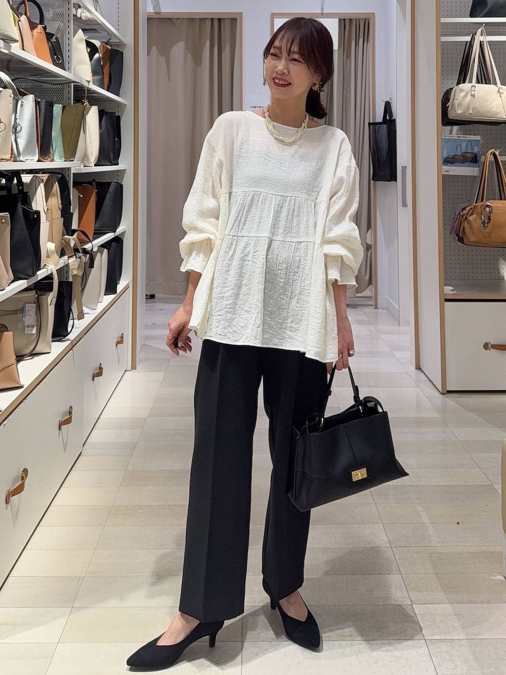 ブラウン系のベスト、ブルー系のデニムパンツ、その他のネックレスを着用したレディースの春コーディネートの5枚目の写真