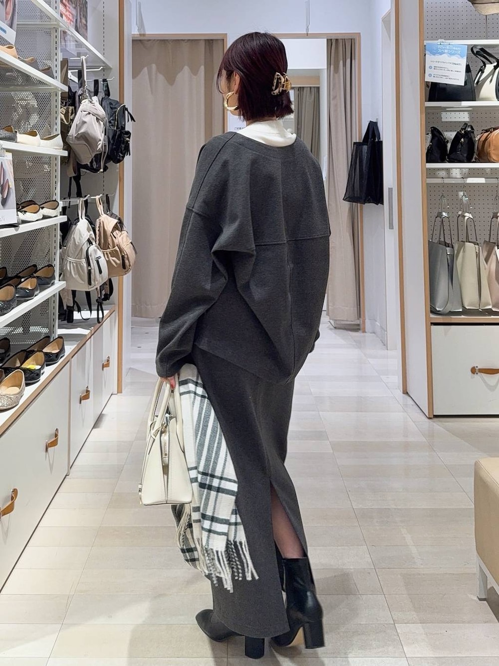 ホワイト系のショルダーバッグ、ブラック系のブーツ、ブラウン系のバレッタ/ヘアクリップを着用したレディースの秋コーディネートの5枚目の写真