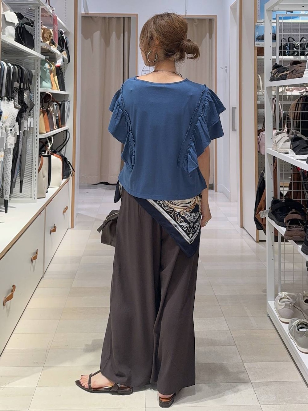 ブラウン系のその他パンツ、ブラウン系のボストンバッグ、ブルー系のTシャツ/カットソーを着用したレディースの夏コーディネートの5枚目の写真