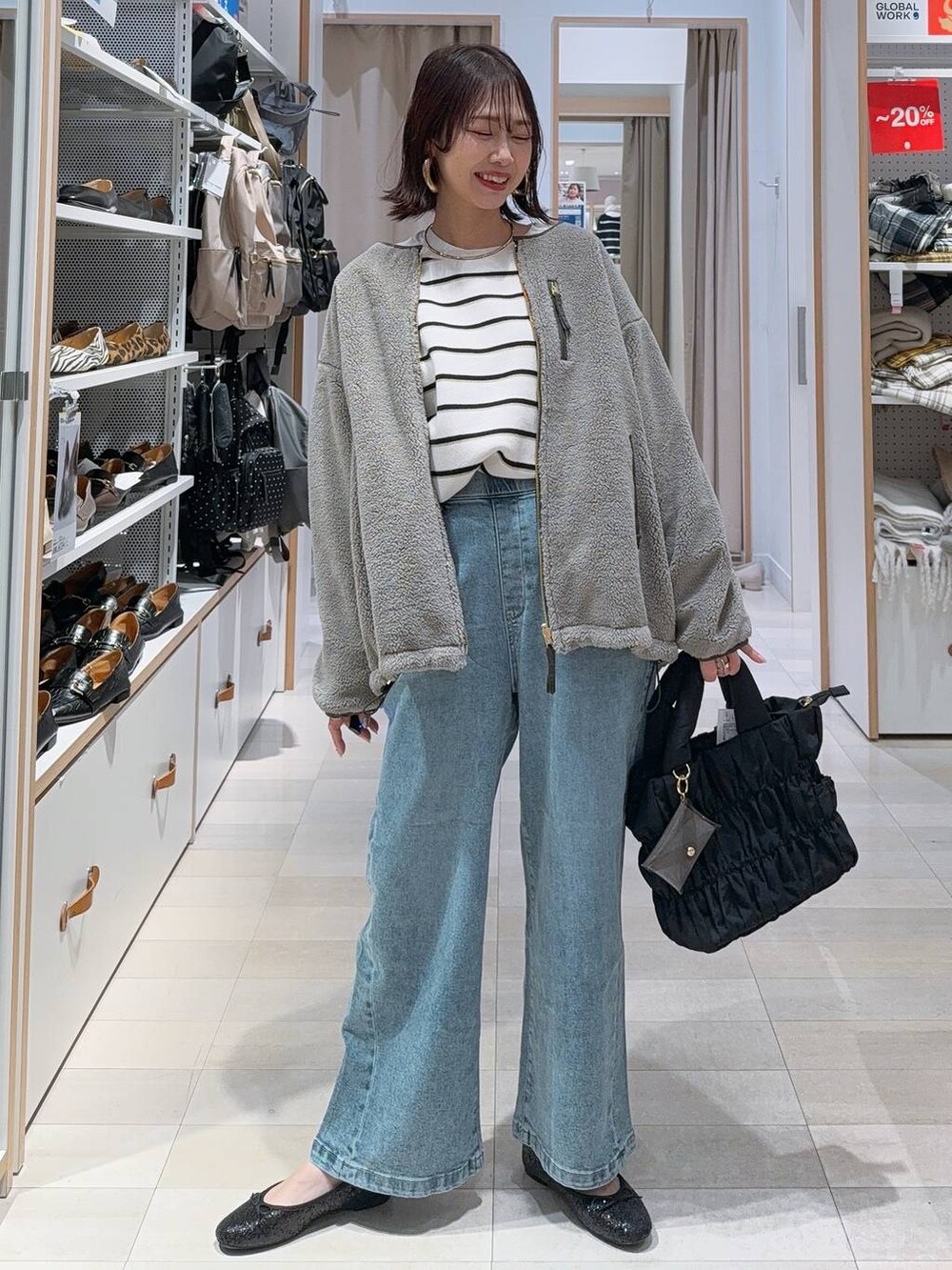 ブラック系のバレエシューズ、グレー系のブルゾン、ブルー系のデニムパンツを着用したレディースの冬コーディネートの2枚目の写真