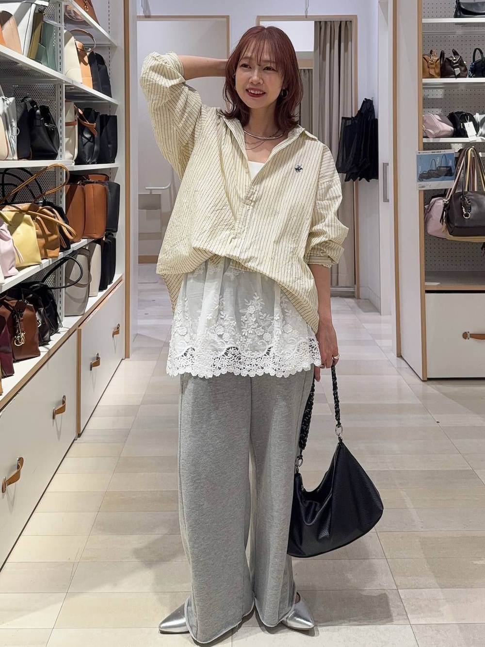 イエロー系のシャツ/ブラウス、ホワイト系のキャミソール、グレー系のスウェットパンツを着用したレディースの春コーディネートの2枚目の写真