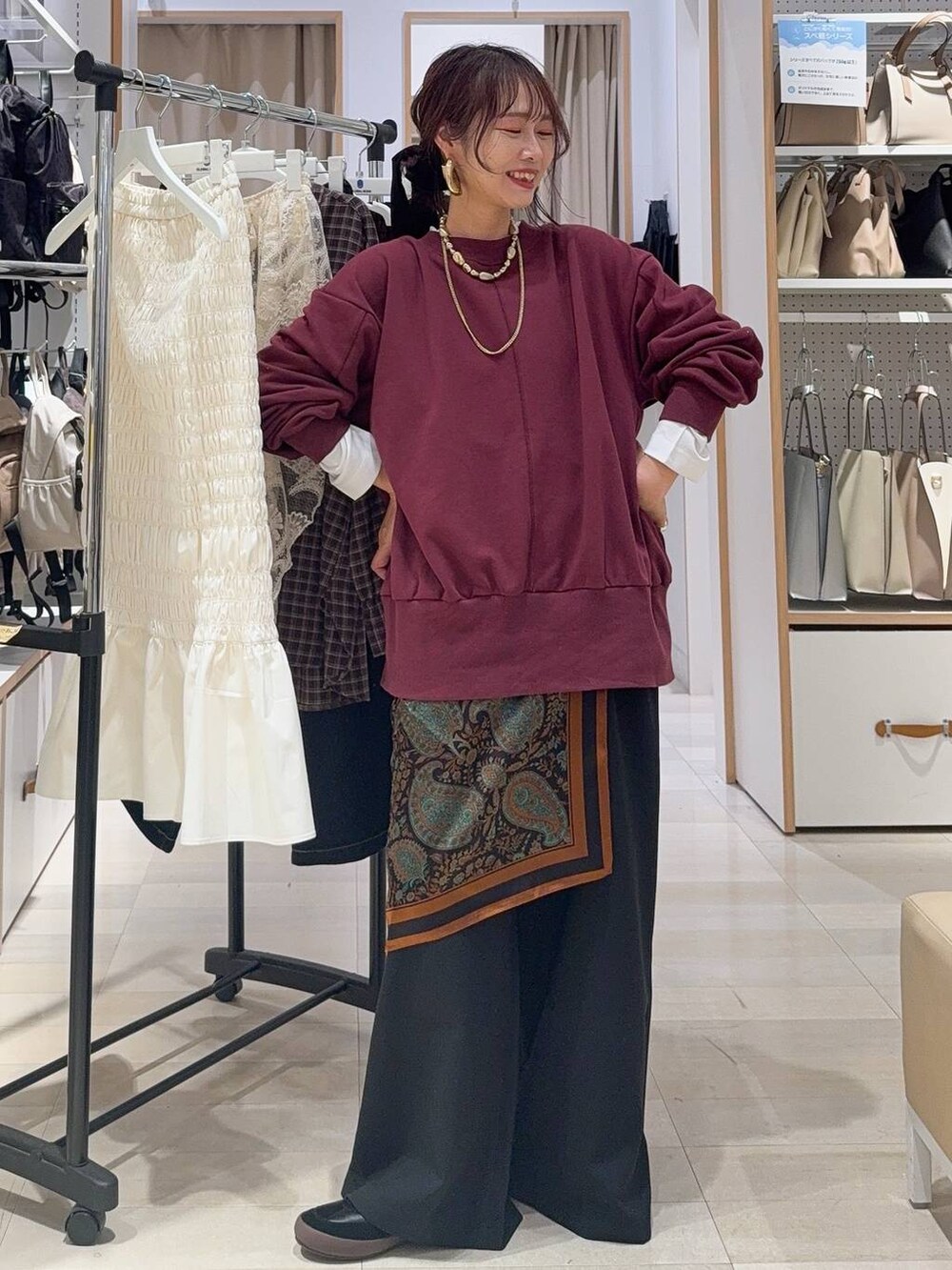 ホワイト系のキャミソール、ブルー系のデニムパンツ、ブラック系のボストンバッグを着用したレディースの秋コーディネートの6枚目の写真