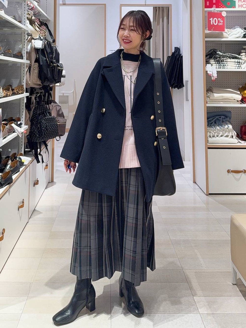 ブラック系のショルダーバッグ、ブルー系のチェスターコート、グレー系のスカートを着用したレディースの冬コーディネートの3枚目の写真