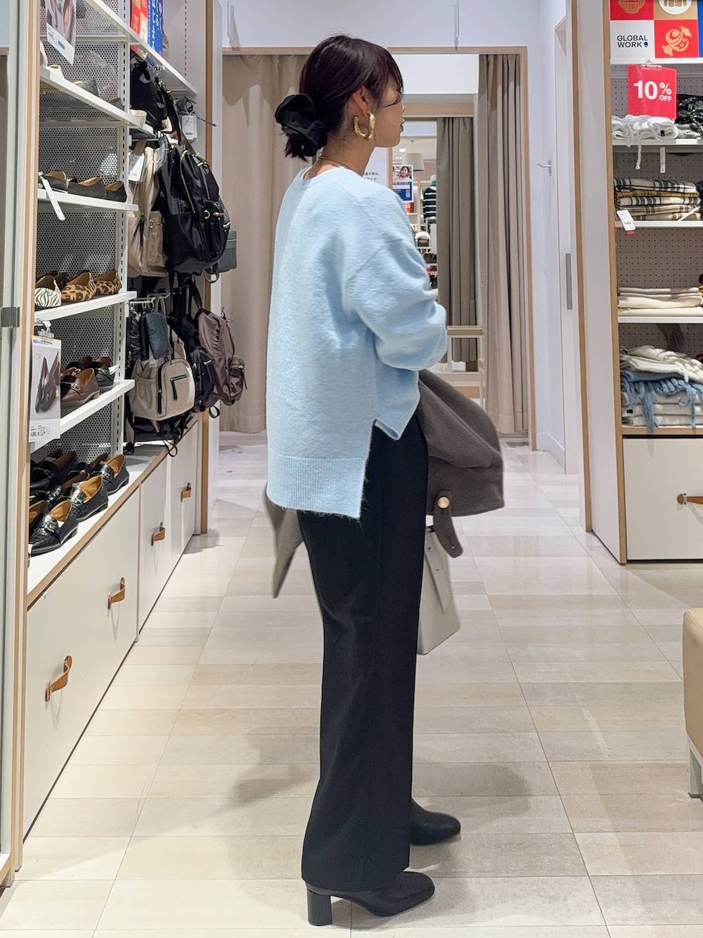 シルバー系のショルダーバッグ、ブラウン系のチェスターコート、ブラック系のその他パンツを着用したレディースの冬コーディネートの6枚目の写真