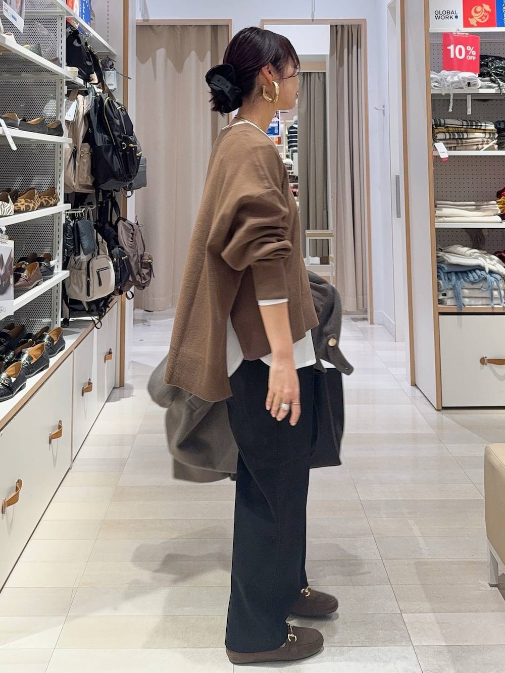 ブラウン系のチェスターコート、ブラック系のその他パンツ、ホワイト系のTシャツ/カットソーを着用したレディースの冬コーディネートの8枚目の写真