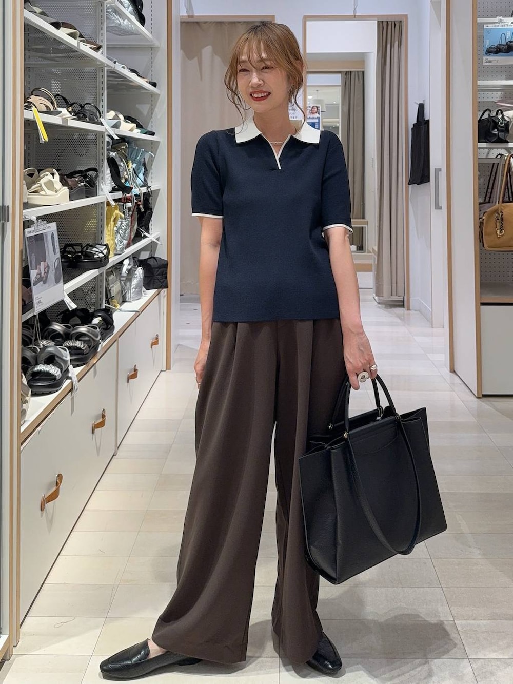 ブルー系のデニムパンツ、ブラック系のサンダル、ブルー系のニット/セーターを着用したレディースの夏コーディネートの2枚目の写真