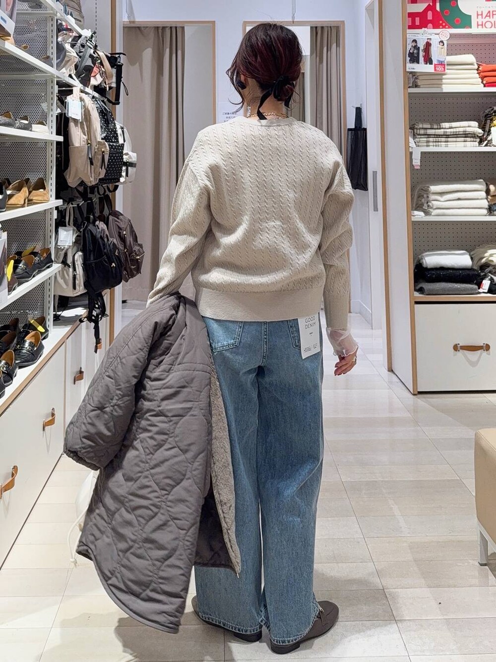 ホワイト系のショルダーバッグ、ブルー系のデニムパンツ、ブラウン系のブルゾンを着用したレディースの冬コーディネートの6枚目の写真