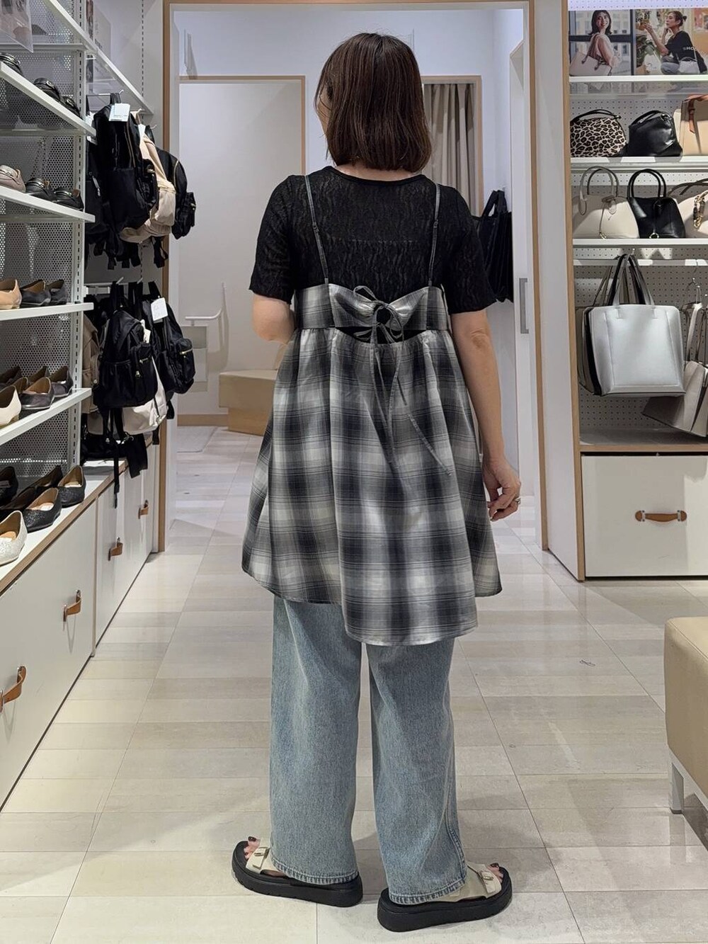 ブルー系のデニムパンツ、ホワイト系のキャミソール、ブラック系のキャミソールを着用したレディースの夏コーディネートの6枚目の写真