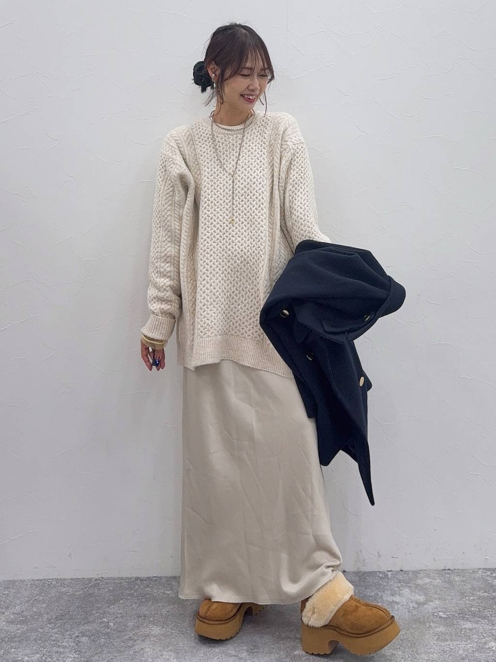 ホワイト系のスカート、ブルー系のチェスターコート、イエロー系のブーツを着用したレディースの冬コーディネートの2枚目の写真