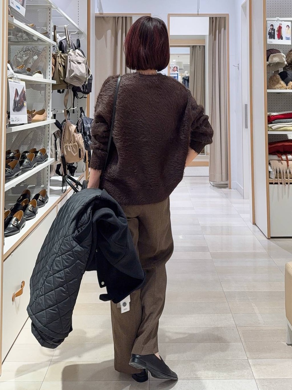 ブラック系のステンカラーコート、ブラウン系のその他パンツ、ブラック系のパンプスを着用したレディースの秋コーディネートの6枚目の写真