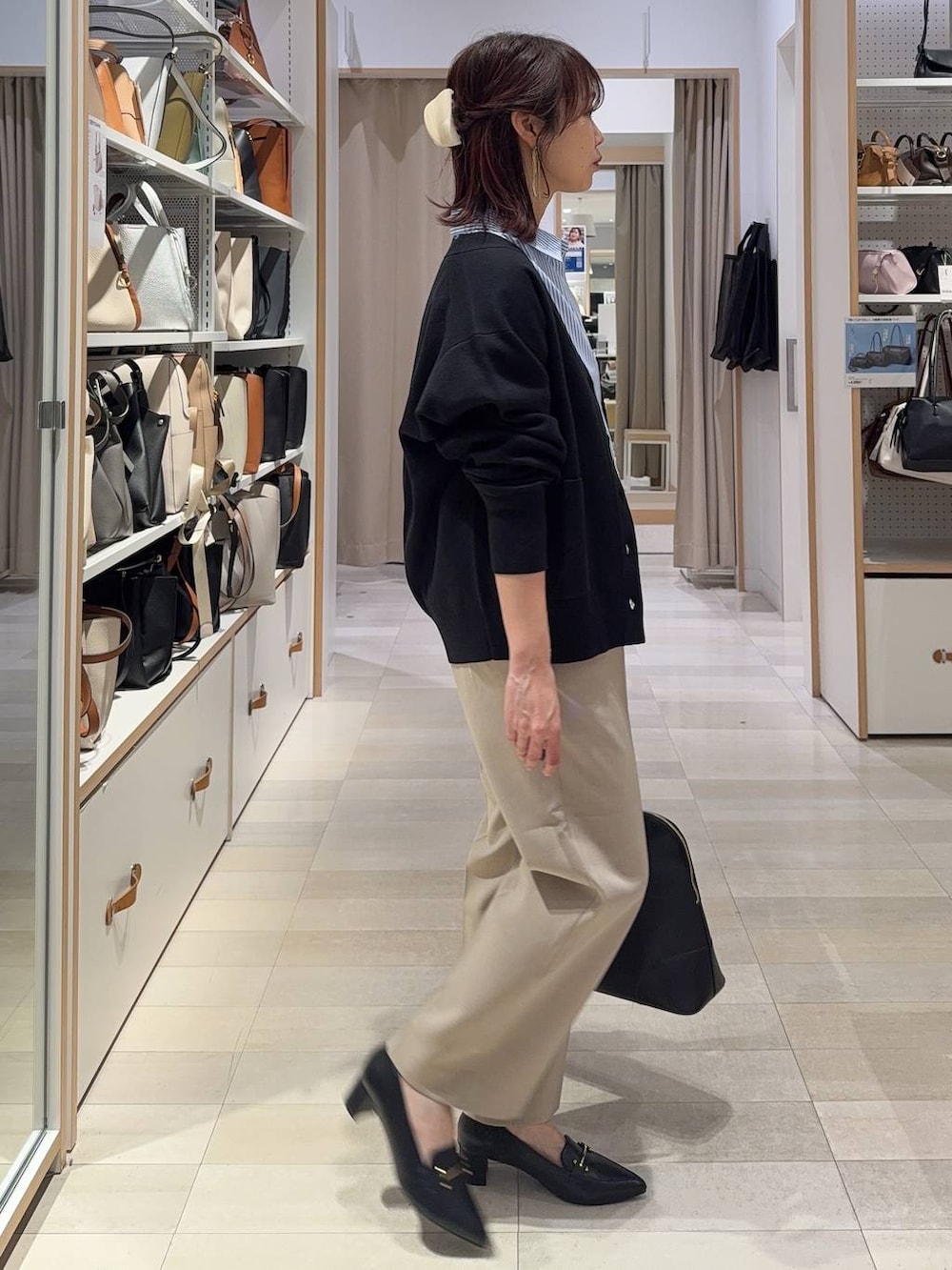 ベージュ系のその他パンツ、ブラック系のカーディガン/ボレロ、ブラック系のボストンバッグを着用したレディースの春コーディネートの3枚目の写真