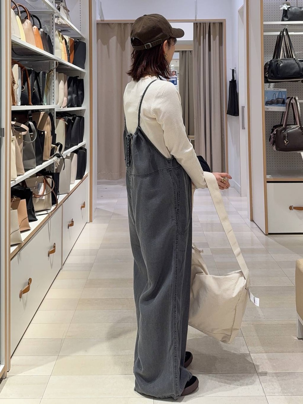 ブルー系のトートバッグ、オレンジ系のカーディガン/ボレロ、ブラック系のスニーカーを着用したレディースの春コーディネートの9枚目の写真