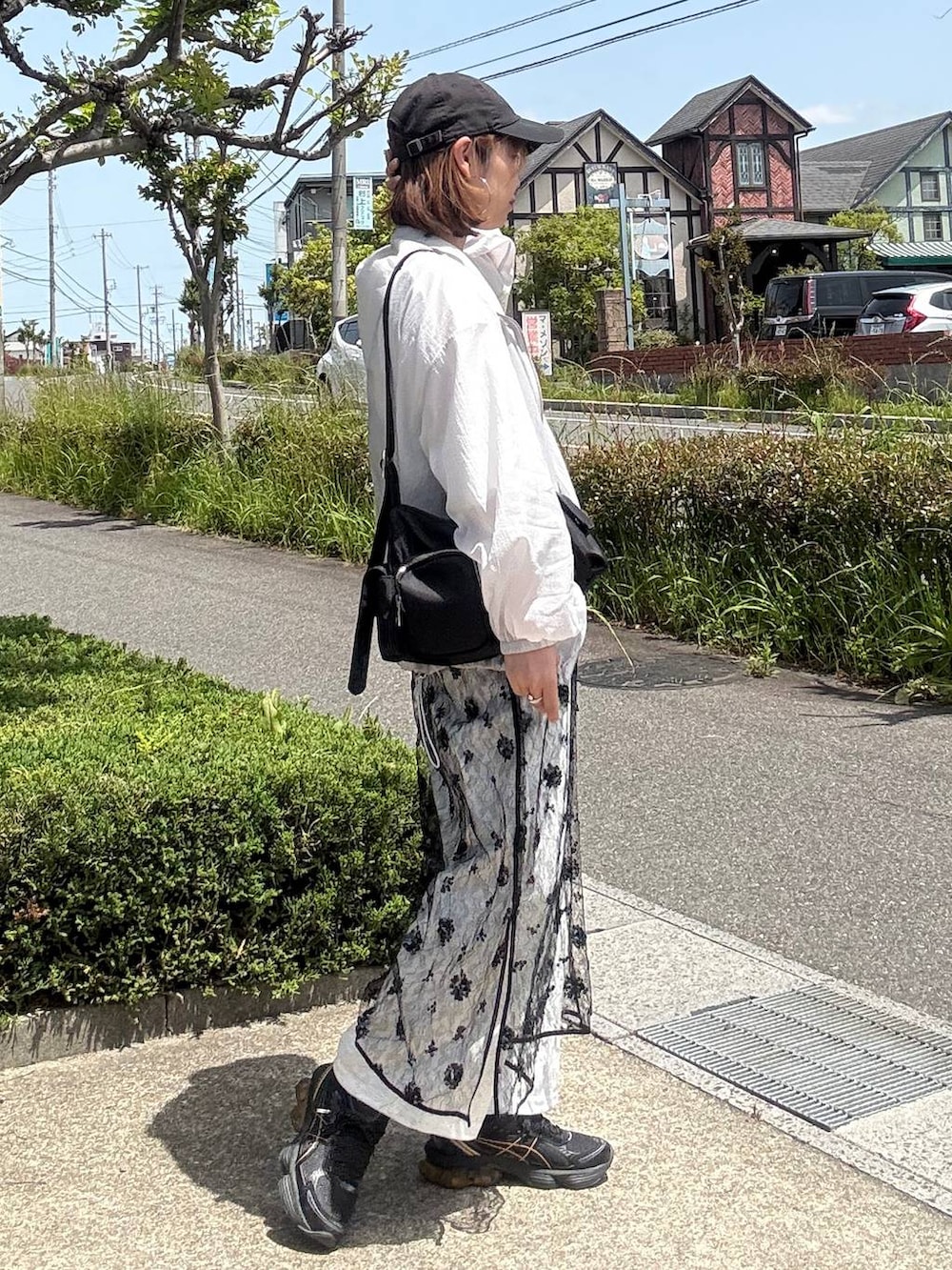 ブラック系のショルダーバッグ、ホワイト系のTシャツ/カットソー、ブラック系のワンピースを着用したレディースの春コーディネートの3枚目の写真