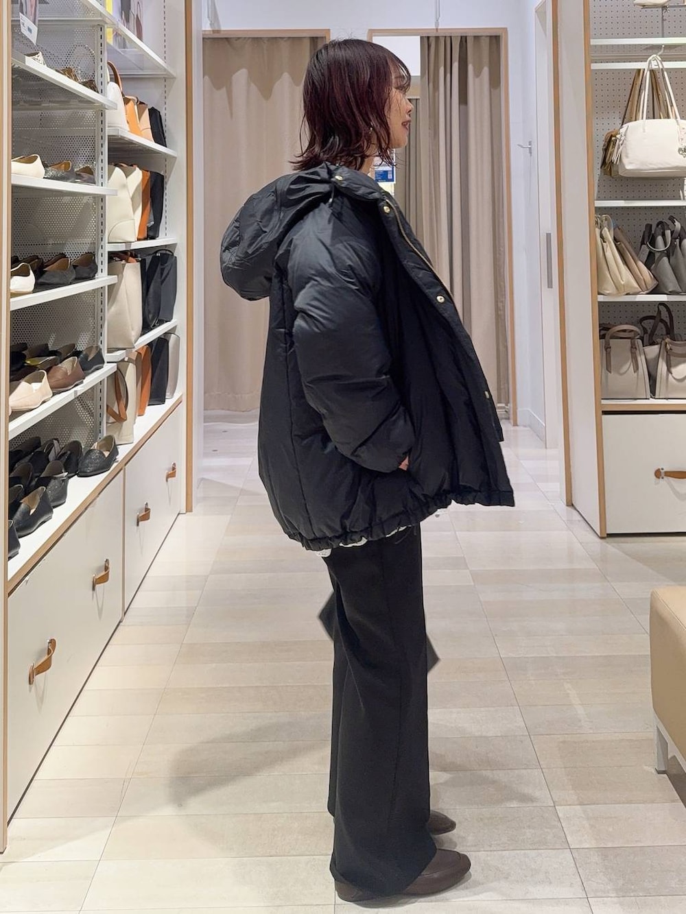 ブルー系のダウンジャケット/コート、ブラウン系のカーディガン/ボレロ、ブラック系のスウェットパンツを着用したレディースの冬コーディネートの3枚目の写真