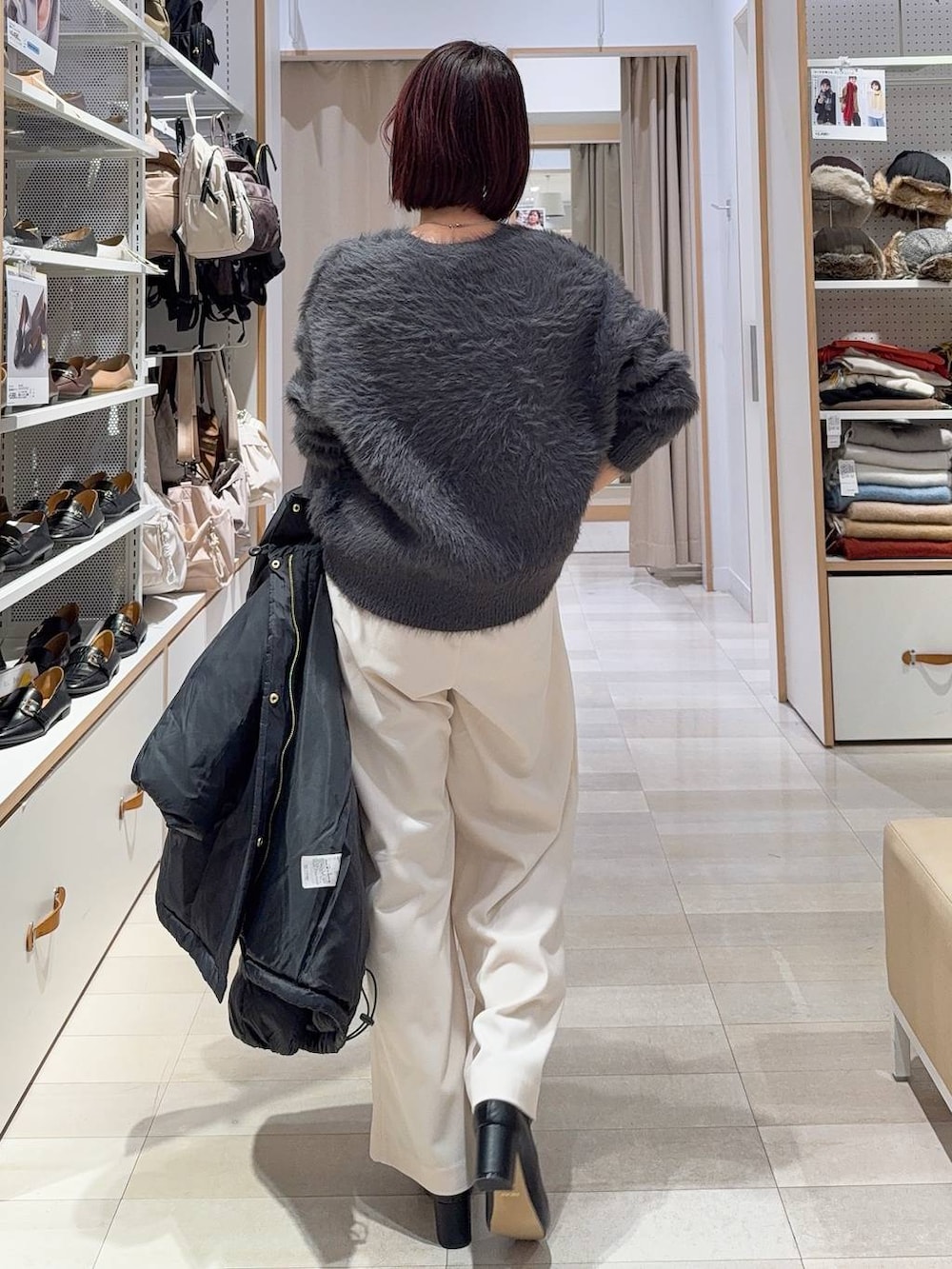 ブラック系のダウンジャケット/コート、ブラック系のトートバッグ、グレー系のその他パンツを着用したレディースの冬コーディネートの6枚目の写真