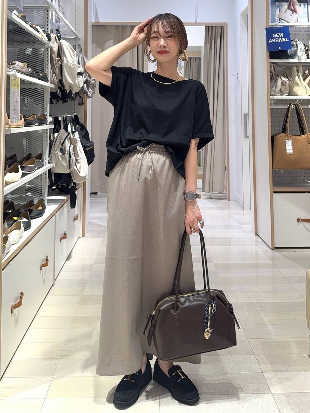 ブラック系のローファー、ブラック系のショルダーバッグ、ブラック系のTシャツ/カットソーを着用したレディースの夏コーディネートの2枚目の写真