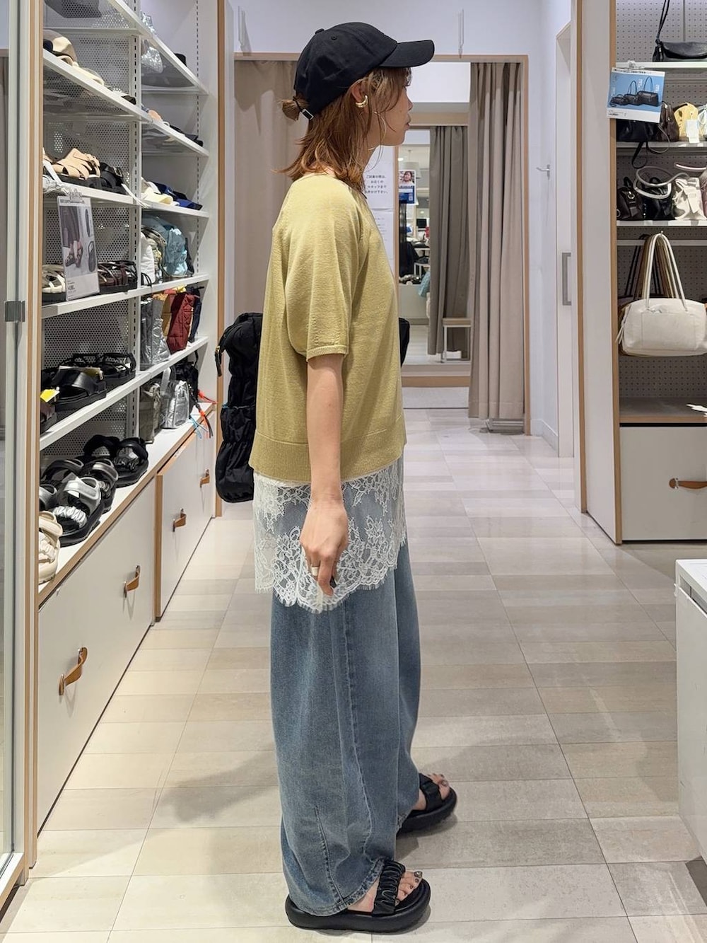 イエロー系のTシャツ/カットソー、ブラック系のトートバッグ、ブルー系のデニムパンツを着用したレディースの夏コーディネートの4枚目の写真