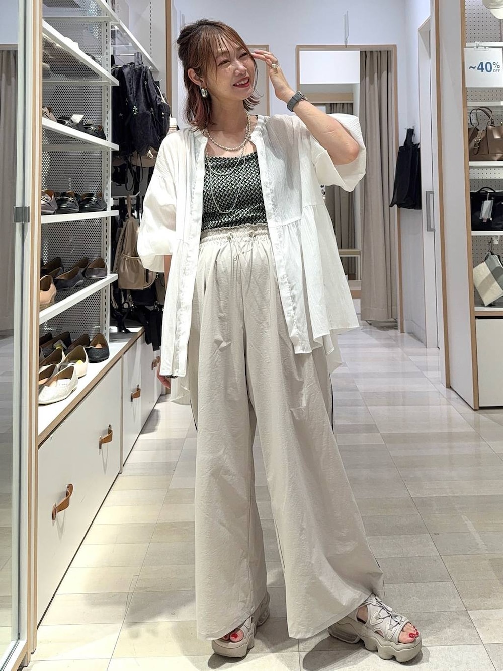 ブラック系のキャミソール、ホワイト系のシャツ/ブラウス、ベージュ系のその他パンツを着用したレディースの夏コーディネートの2枚目の写真