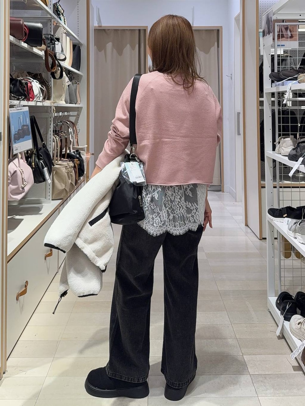 ホワイト系のTシャツ/カットソー、ブラック系のショルダーバッグ、ブラック系のデニムパンツを着用したレディースの秋コーディネートの8枚目の写真