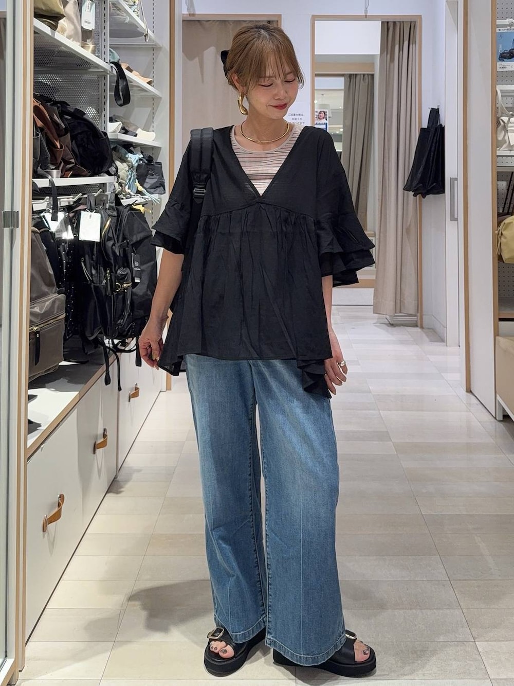ブルー系のデニムパンツ、ベージュ系のタンクトップ、ホワイト系のTシャツ/カットソーを着用したレディースの春コーディネートの3枚目の写真