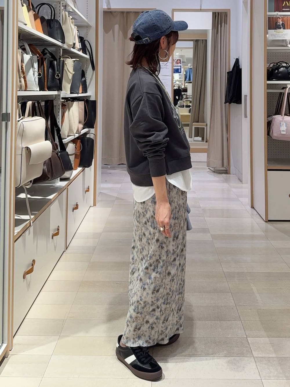 ブラック系のスニーカー、ブラック系のショルダーバッグ、ホワイト系のTシャツ/カットソーを着用したレディースの春コーディネートの7枚目の写真