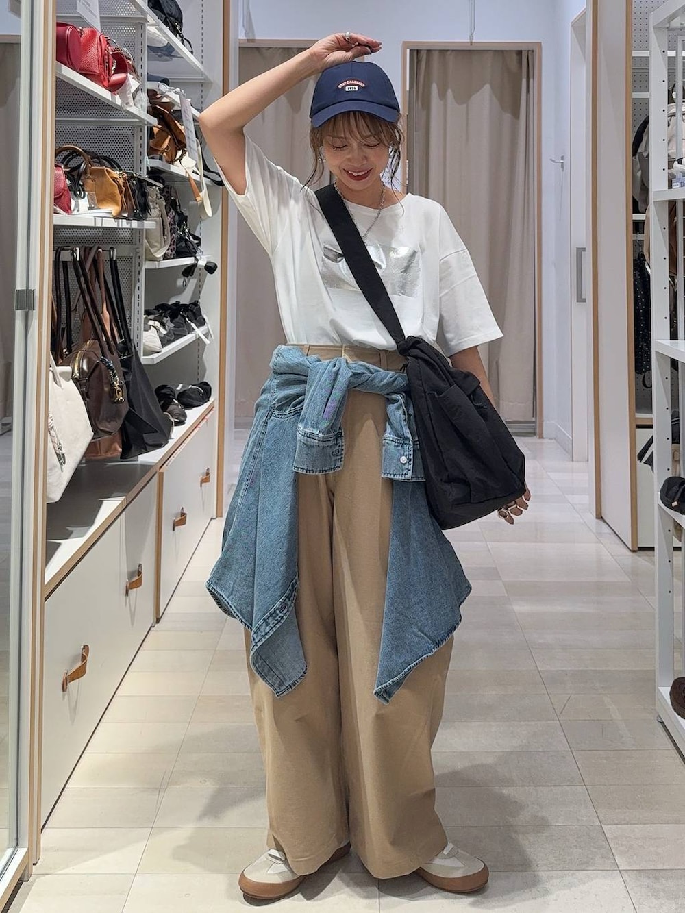 ホワイト系のスニーカー、ブラック系のショルダーバッグ、ホワイト系のTシャツ/カットソーを着用したレディースの秋コーディネートの2枚目の写真
