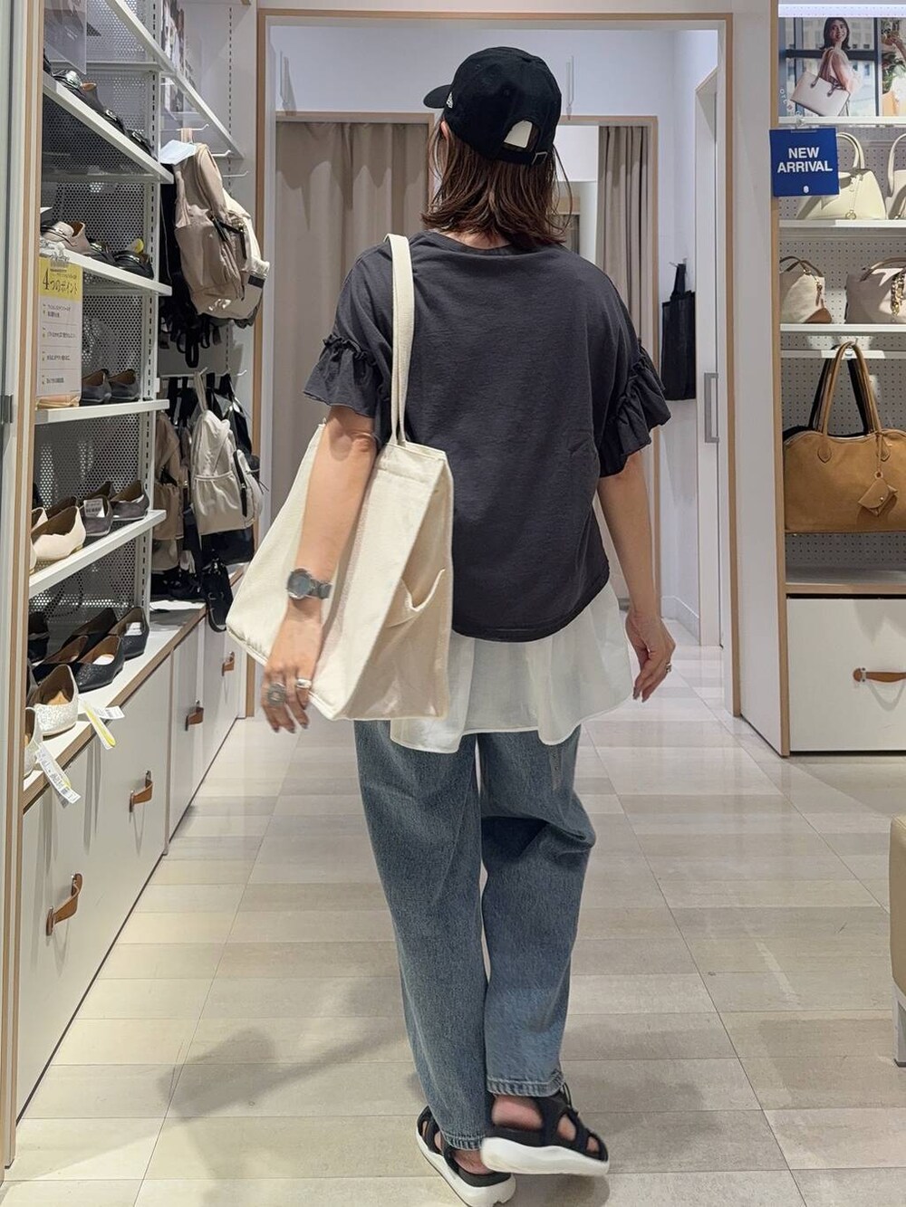 ブラック系のサンダル、ブラック系のTシャツ/カットソー、ブルー系のデニムパンツを着用したレディースの夏コーディネートの4枚目の写真