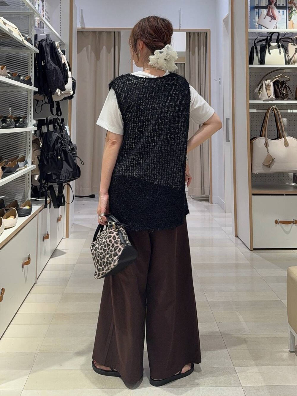 ブルー系のジャンパースカート、ベージュ系のボストンバッグ、ブラック系のサンダルを着用したレディースの夏コーディネートの6枚目の写真