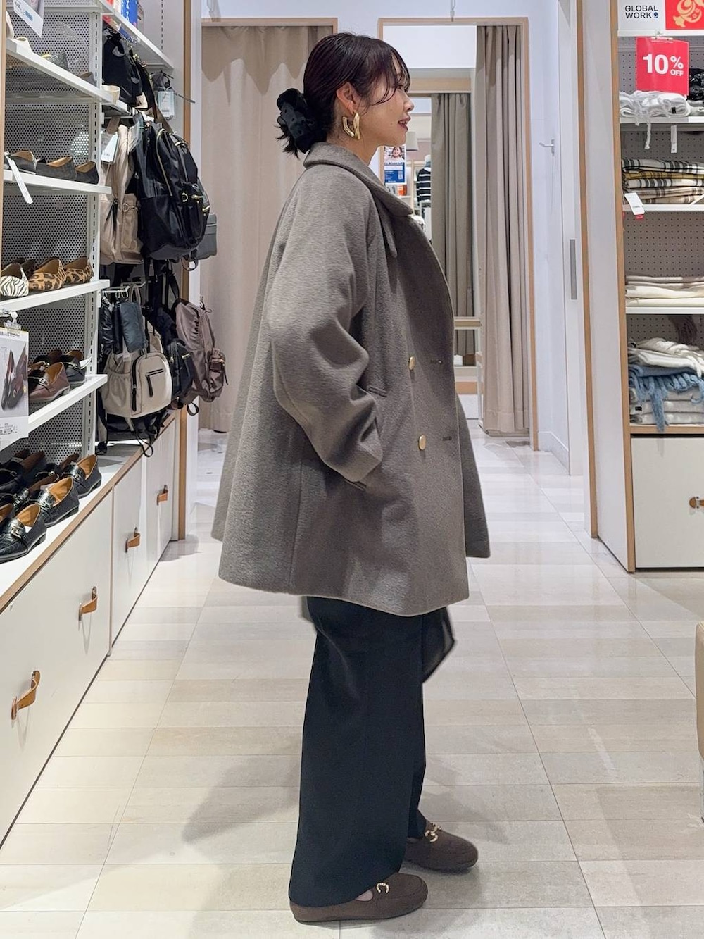 ブラウン系のチェスターコート、ブラック系のその他パンツ、ホワイト系のTシャツ/カットソーを着用したレディースの冬コーディネートの6枚目の写真