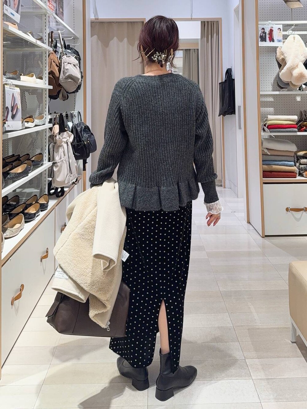 ブラウン系のボストンバッグ、ホワイト系のTシャツ/カットソー、ブラック系のスカートを着用したレディースの秋コーディネートの8枚目の写真