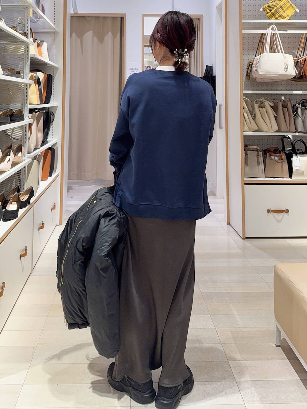 その他のショルダーバッグ、ブラック系のダウンジャケット/コート、ホワイト系のニット/セーターを着用したレディースの冬コーディネートの6枚目の写真