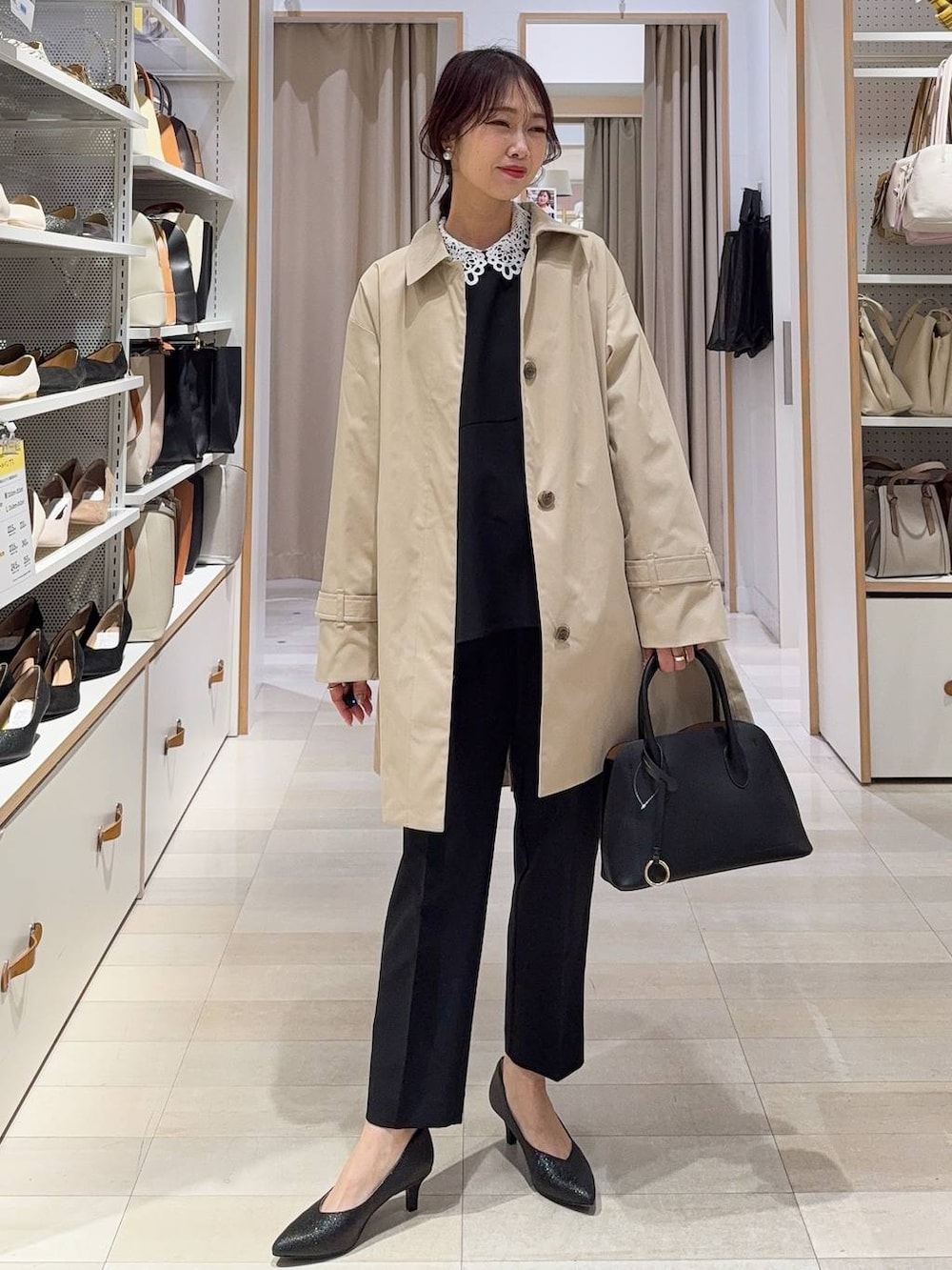 ホワイト系のショルダーバッグ、ブラック系のパンプス、ブラック系のセットアップを着用したレディースの冬コーディネートの2枚目の写真