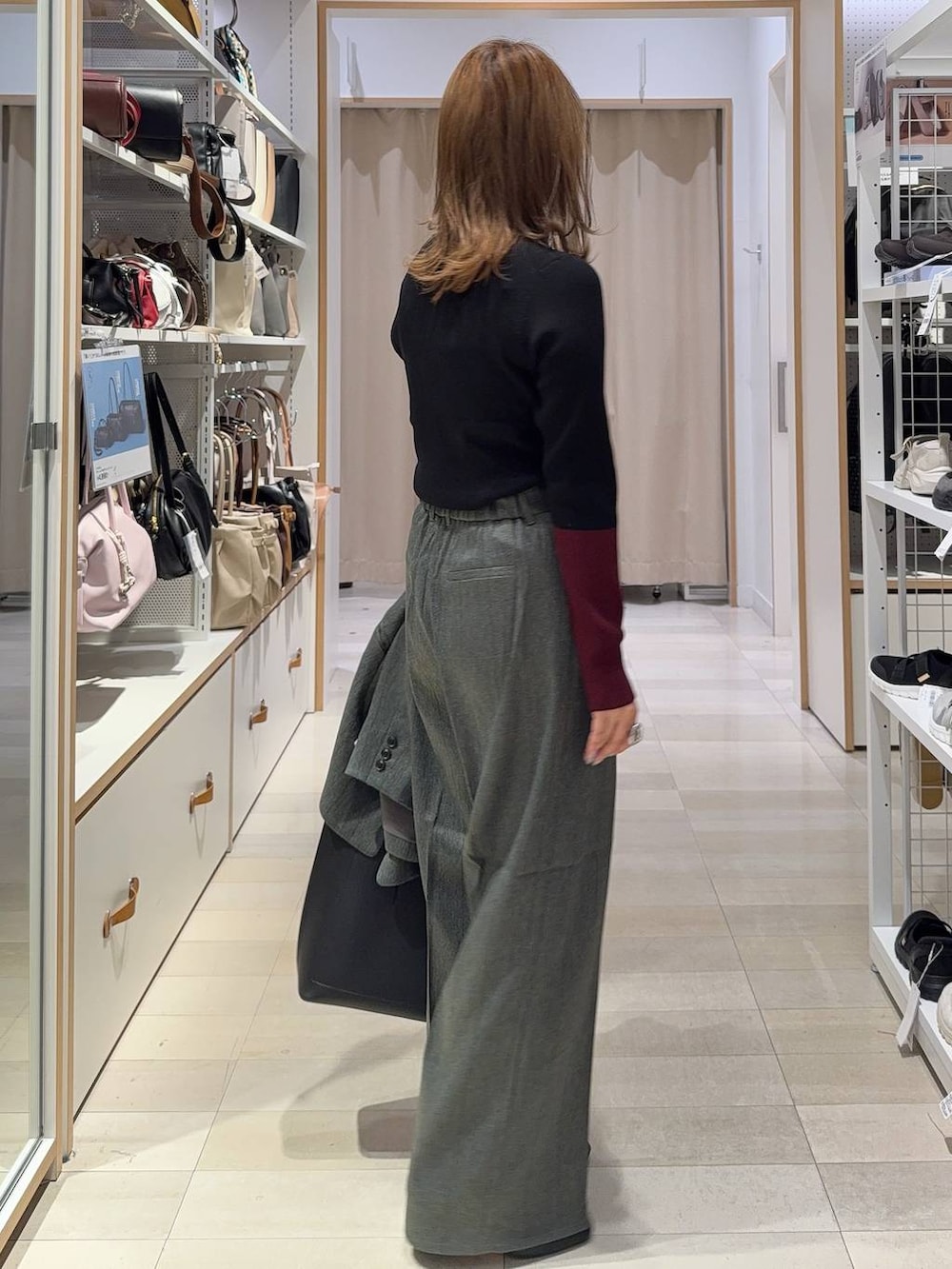 グレー系のその他パンツ、ブラック系のブーツ、ブラック系のトートバッグを着用したレディースの秋コーディネートの6枚目の写真