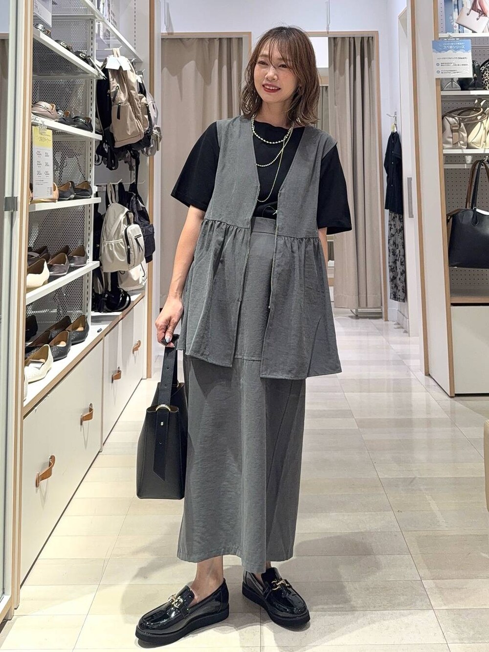 ブラウン系のショルダーバッグ、ブラウン系のキャミソール、ブルー系のデニムパンツを着用したレディースの秋コーディネートの4枚目の写真