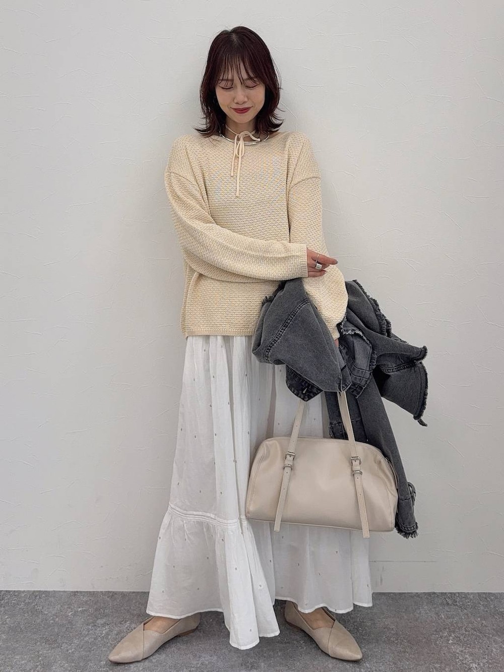 ホワイト系のパンプス、ベージュ系のショルダーバッグ、シルバー系のネックレスを着用したレディースの春コーディネートの3枚目の写真