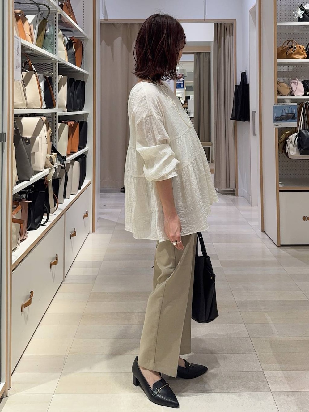 ベージュ系のその他パンツ、ベージュ系のベスト、ブラック系のハンドバッグを着用したレディースの春コーディネートの6枚目の写真