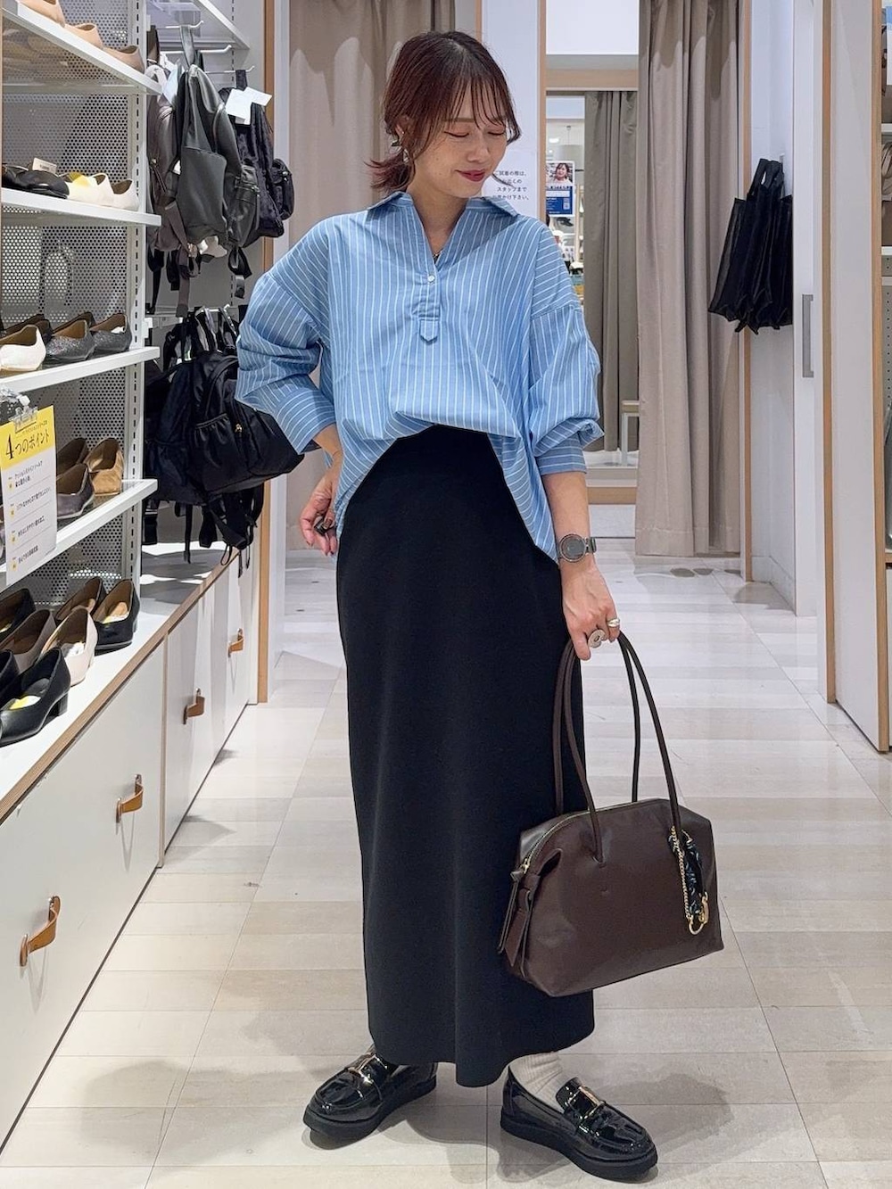 ブラック系のローファー、ブラウン系のボストンバッグ、ブラック系のスウェットを着用したレディースの秋コーディネートの2枚目の写真