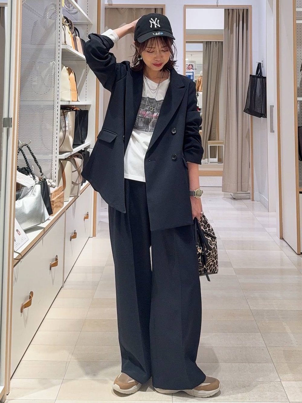 ブラック系のローファー、ブラック系のボストンバッグ、ブルー系のテーラードジャケットを着用したレディースの冬コーディネートの4枚目の写真