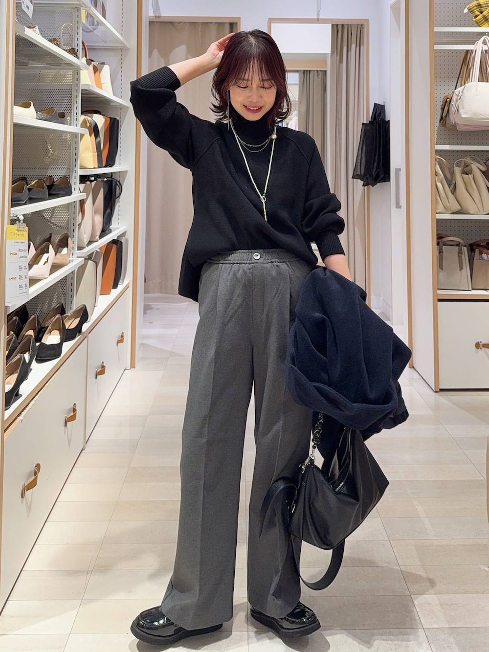 ブラック系のローファー、ブルー系のチェスターコート、グレー系のその他パンツを着用したレディースの冬コーディネートの2枚目の写真