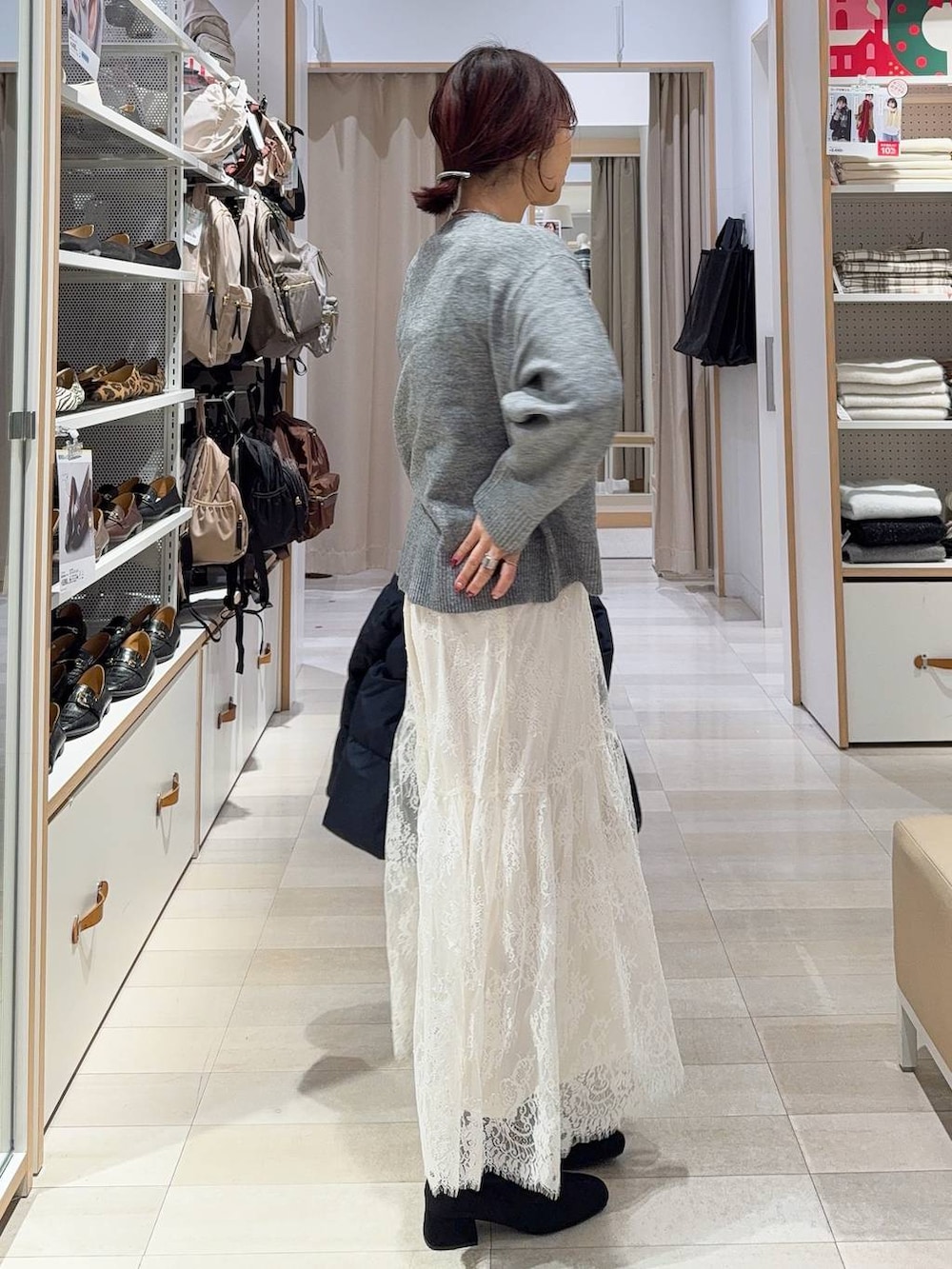 ブラック系のショルダーバッグ、ブルー系のダウンジャケット/コート、グレー系のワンピースを着用したレディースの冬コーディネートの7枚目の写真