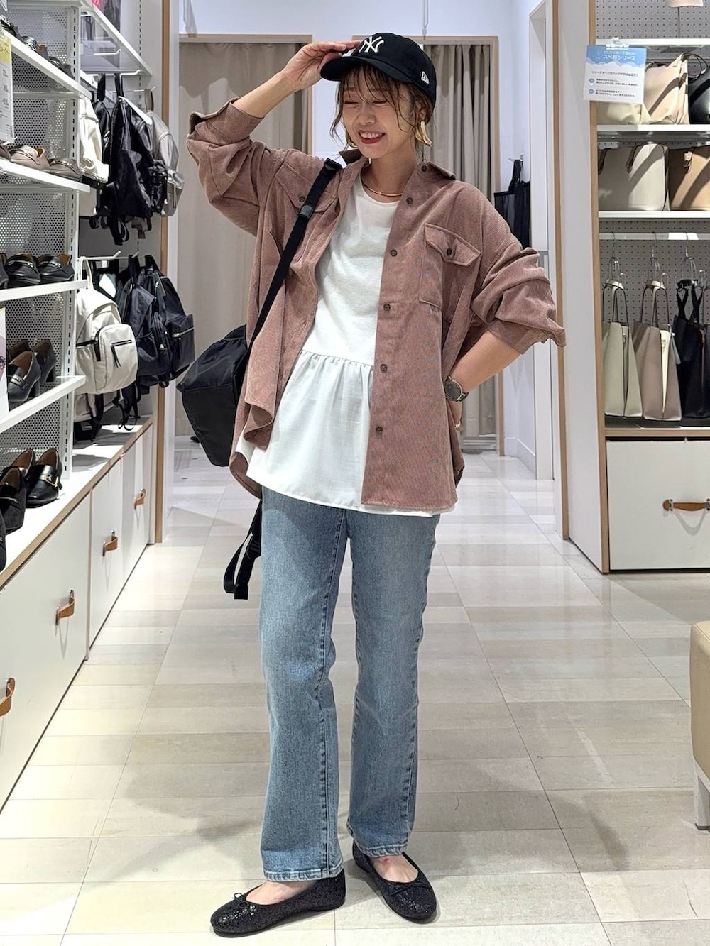 ブラック系のパンプス、ブラウン系のスラックス、ブラック系のボストンバッグを着用したレディースの秋コーディネートの5枚目の写真