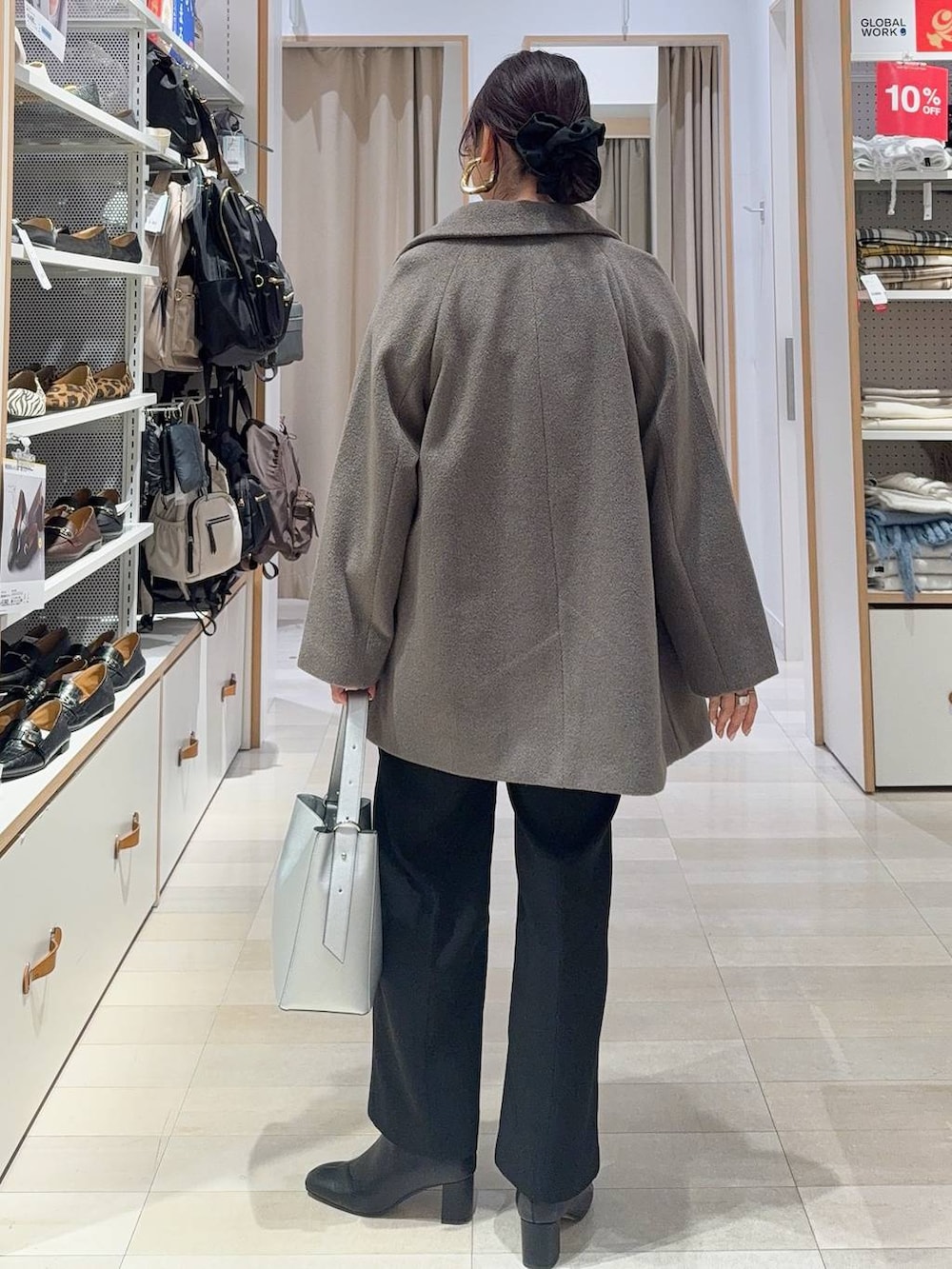 シルバー系のショルダーバッグ、ブラウン系のチェスターコート、ブラック系のその他パンツを着用したレディースの冬コーディネートの5枚目の写真