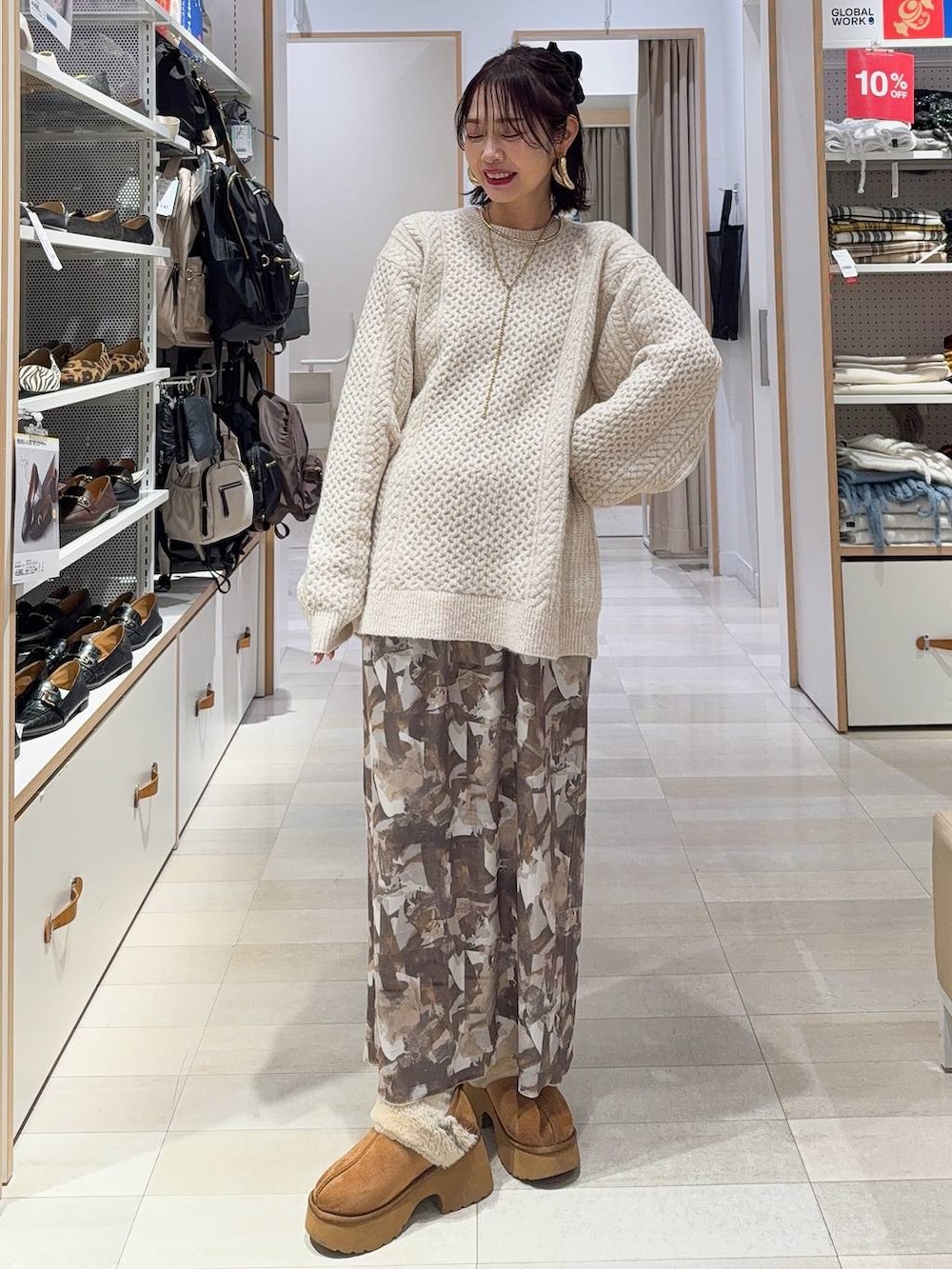 ブラック系のその他アウター、イエロー系のブーツ、ホワイト系のニット/セーターを着用したレディースの冬コーディネートの4枚目の写真