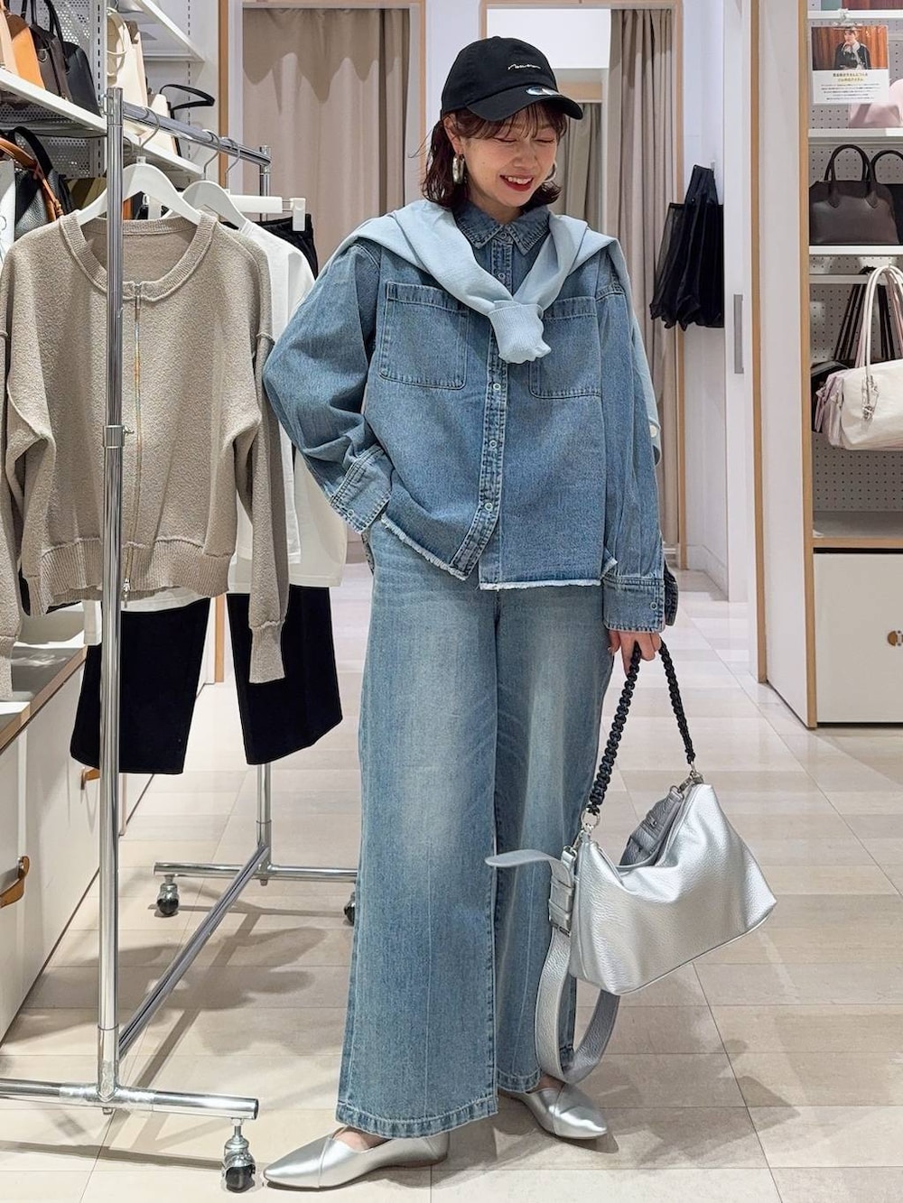 シルバー系のパンプス、ブラック系のキャミソール、ブルー系のデニムパンツを着用したレディースの冬コーディネートの6枚目の写真