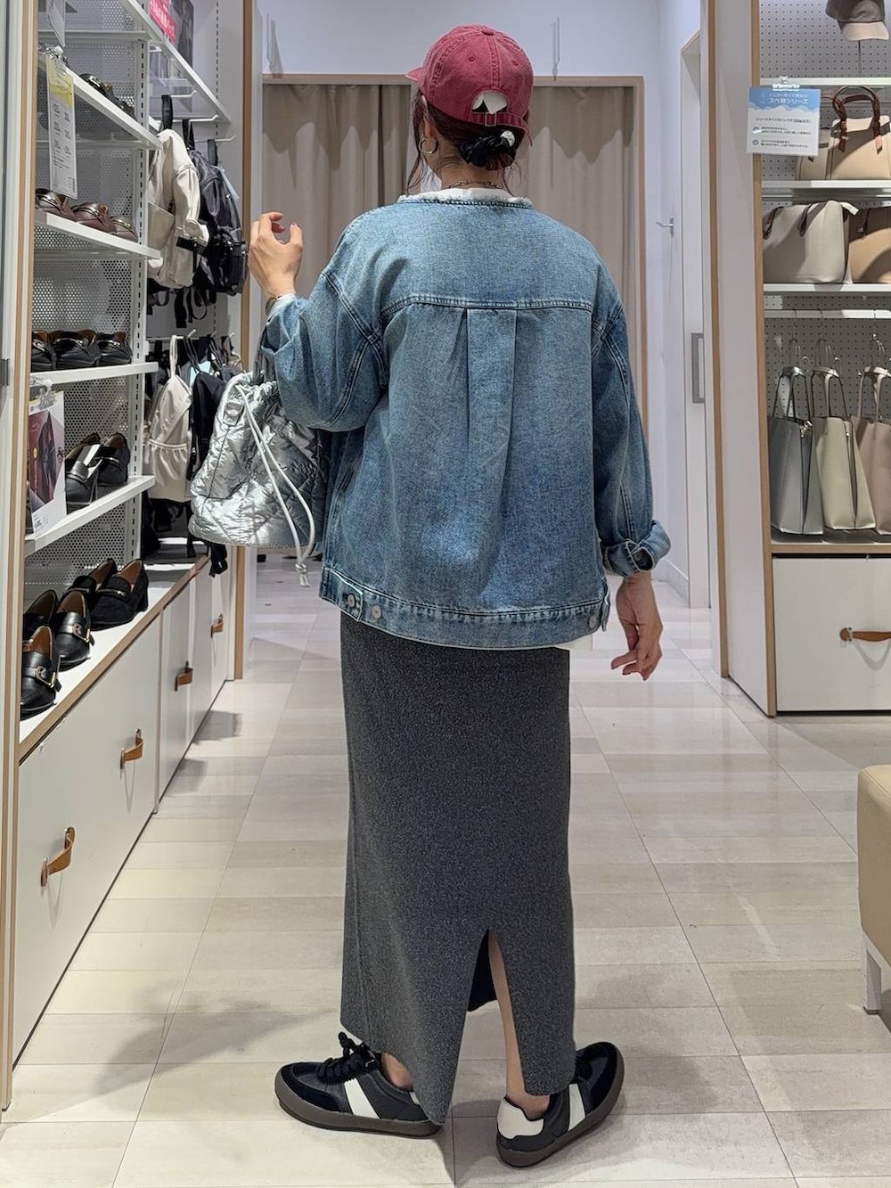 ブラック系のスニーカー、ブルー系のデニムジャケット、シルバー系のハンドバッグを着用したレディースの秋コーディネートの7枚目の写真