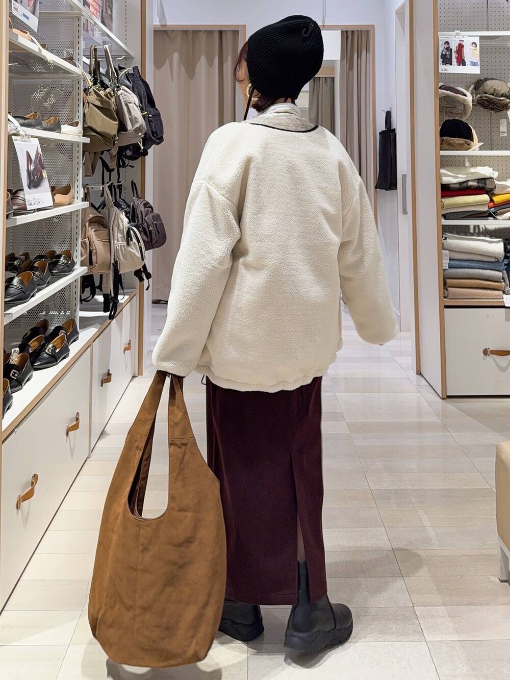 ホワイト系のブルゾン、レッド系のスカート、ベージュ系のトートバッグを着用したレディースの秋コーディネートの5枚目の写真